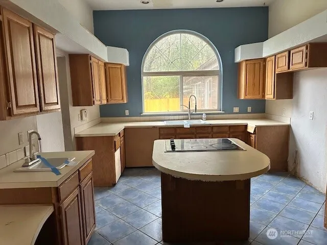 a kitchen with stainless steel appliances granite countertop a refrigerator a sink and a stove