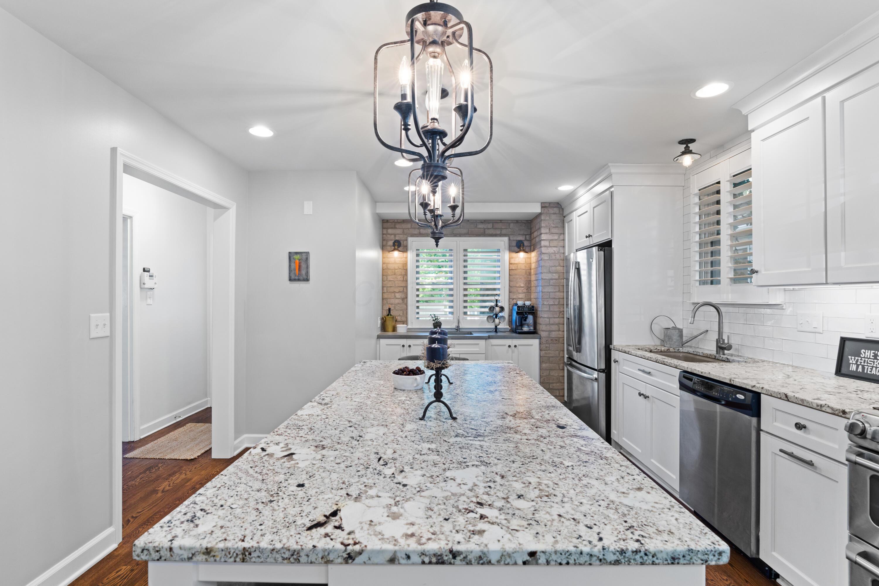 41 Aldrich Road Columbus, OH 43214 - Photo 24 of 52 Remodeled Kitchen and Eat-in Area, completed by Dave Fox® provides all of the modern conveniences of today while still highlighting the character of a 1930s home. Large Leathered Granite Island with countertop seating and pendant lighting. Shaker-style cabinetry with soft-close hinges and drawers & pull-out drawers, including trash pull outs, spice drawer and pull-out pantry. Gas range with double-oven & vent hood. Single basin sink & subway tile backsplash plus a cocktail/coffee bar with Restoration Hardware® with insta-hot faucet, concrete countertop and sink with exposed brick wall!