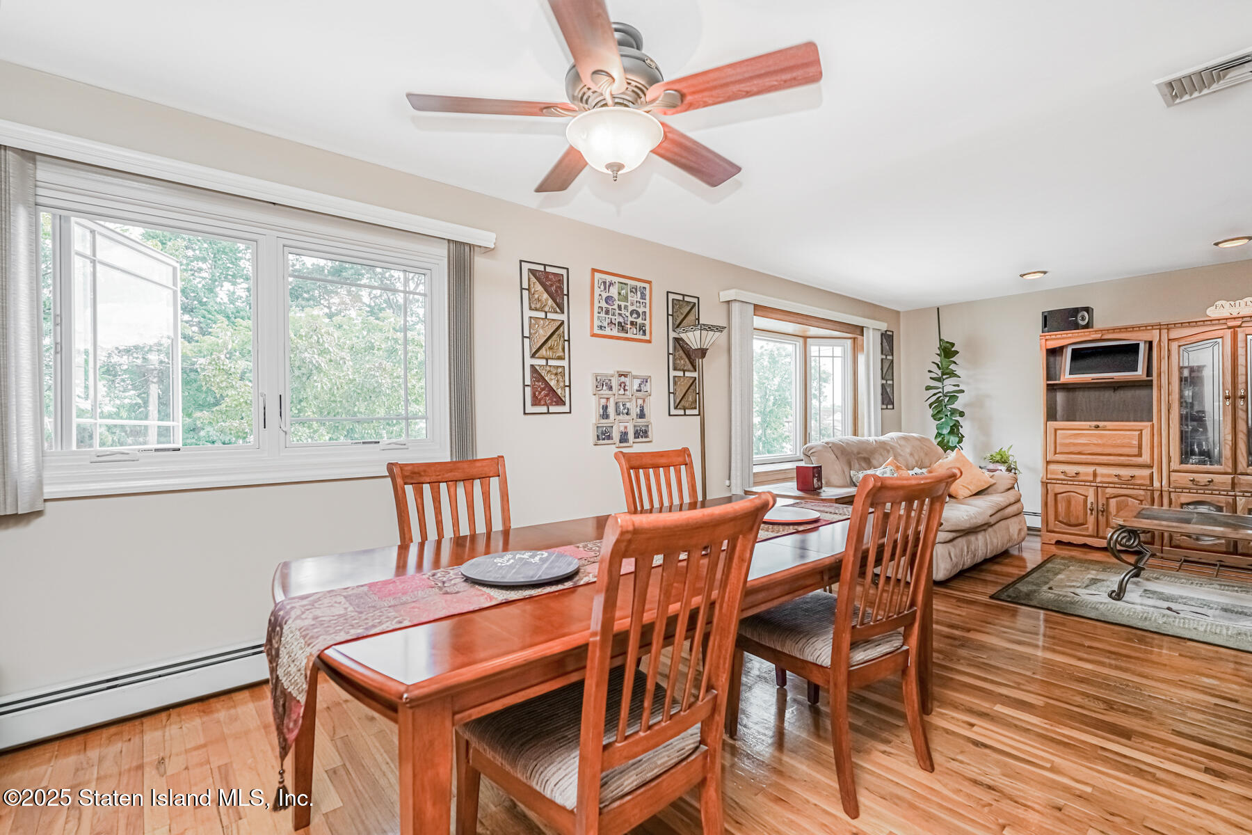 149 Rensselaer Avenue Staten Island, NY 10312 - Photo 15 of 33 a dining room with furniture a flat screen tv and wooden floor