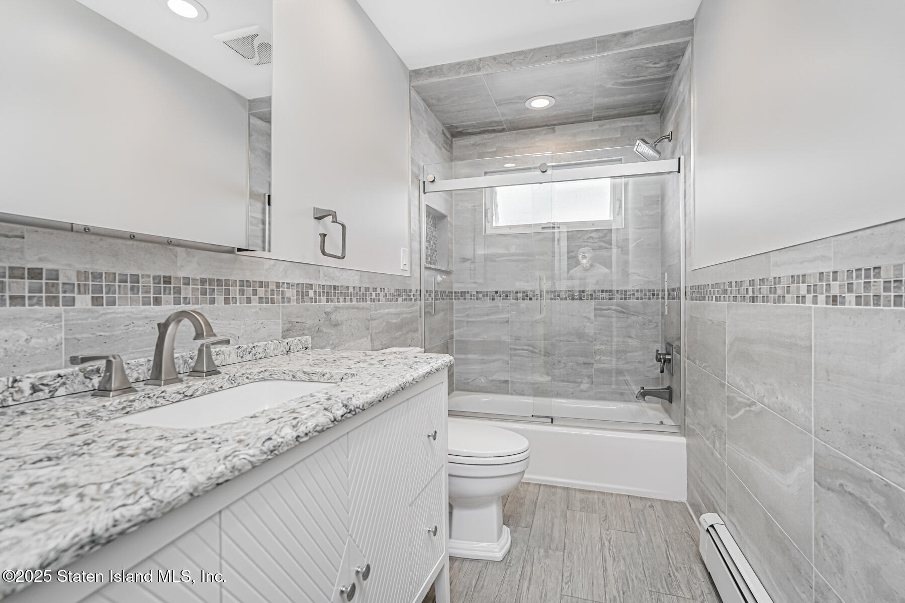 149 Rensselaer Avenue Staten Island, NY 10312 - Photo 20 of 33 a bathroom with a granite countertop sink a toilet and bathtub