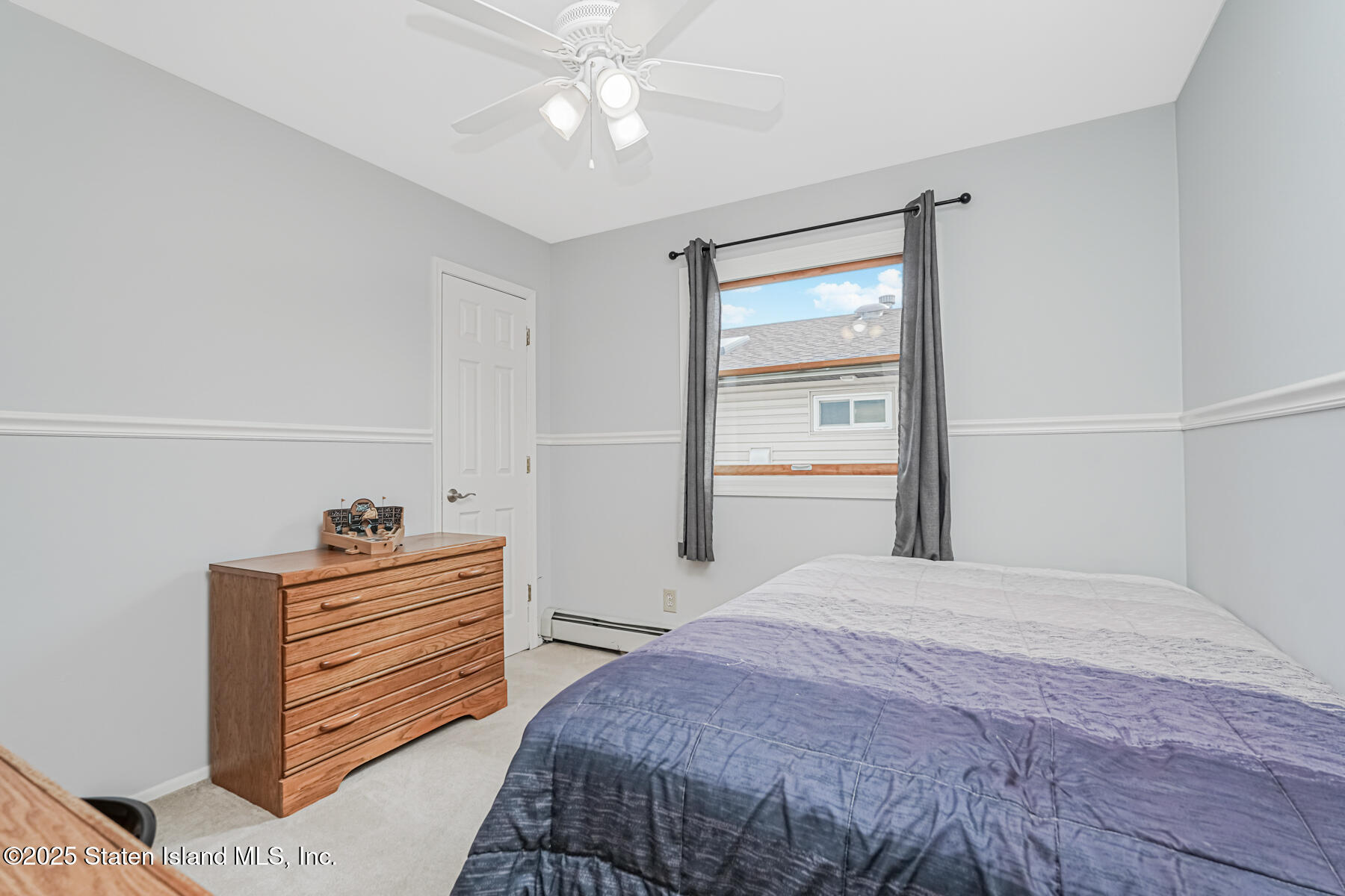 149 Rensselaer Avenue Staten Island, NY 10312 - Photo 24 of 33 a bedroom with a bed and a chandelier fan