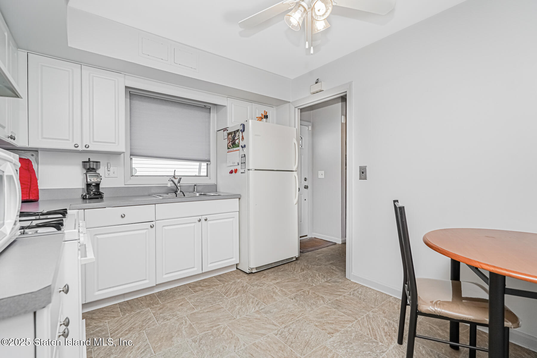 149 Rensselaer Avenue Staten Island, NY 10312 - Photo 9 of 33 a kitchen with white cabinets and refrigerator