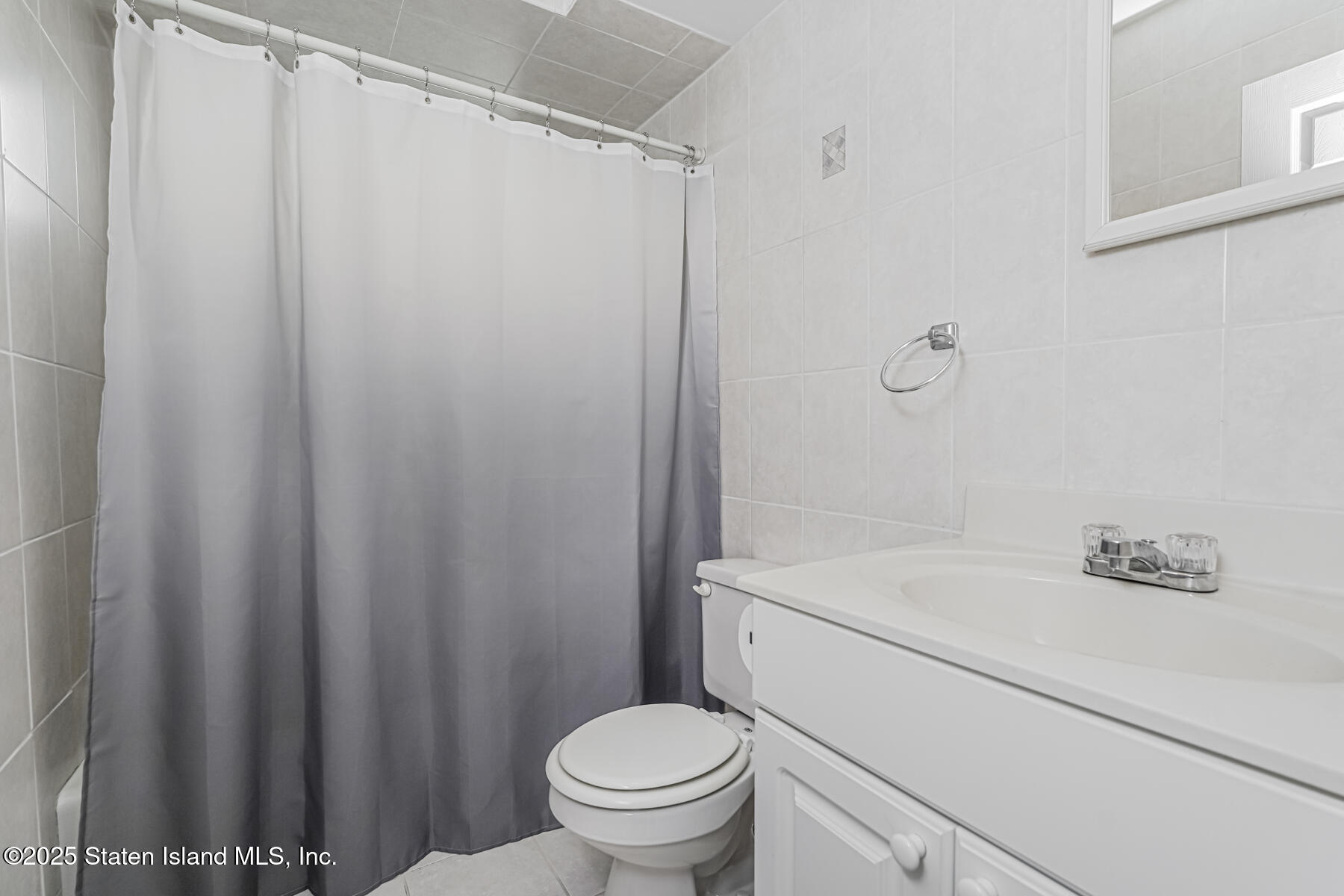 149 Rensselaer Avenue Staten Island, NY 10312 - Photo 10 of 33 a bathroom with a sink a toilet and shower curtain