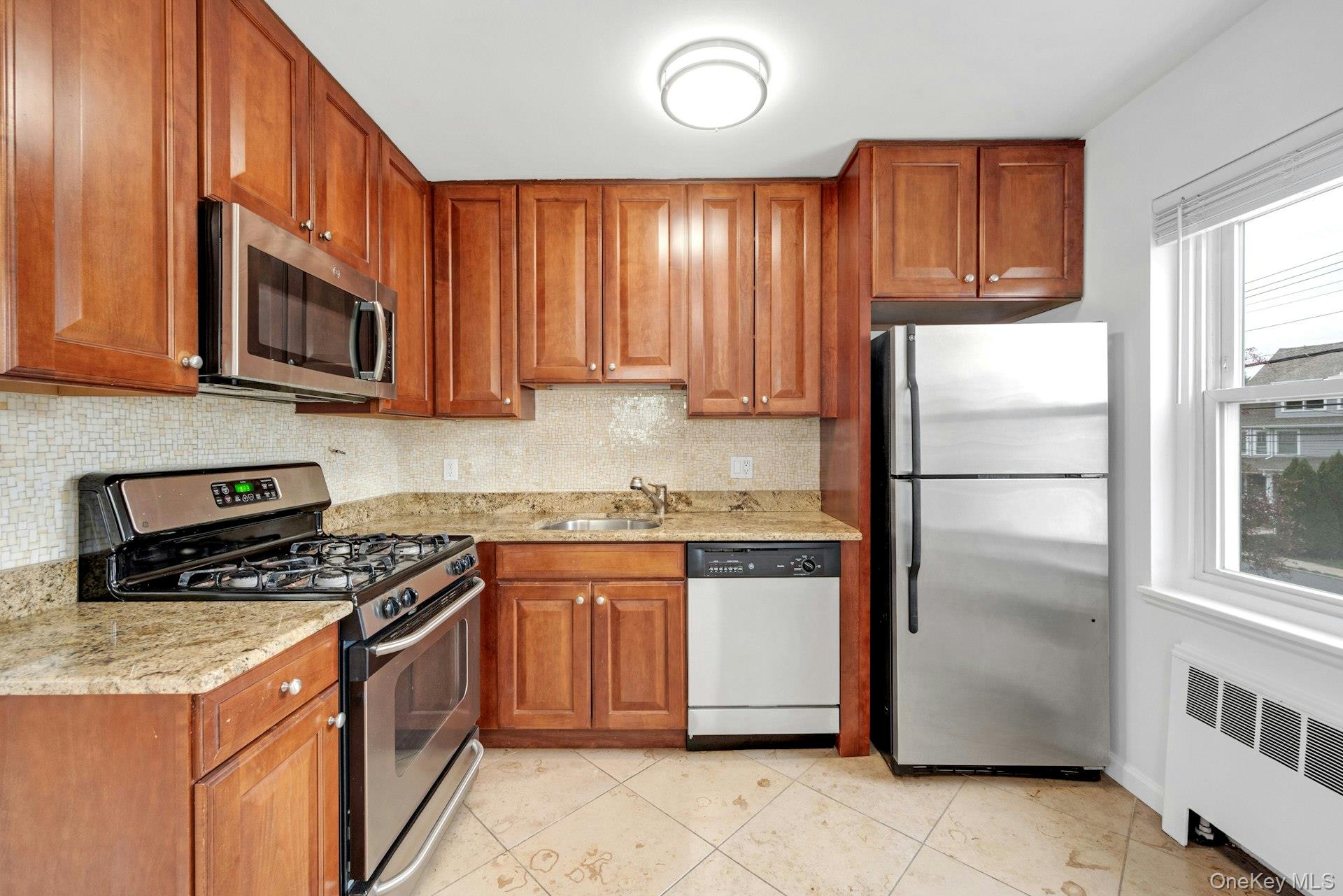 184 Purchase Street, Unit 12 Rye, NY 10580 - Photo 12 of 33 a kitchen with stainless steel appliances granite countertop a refrigerator stove top oven a sink and dishwasher