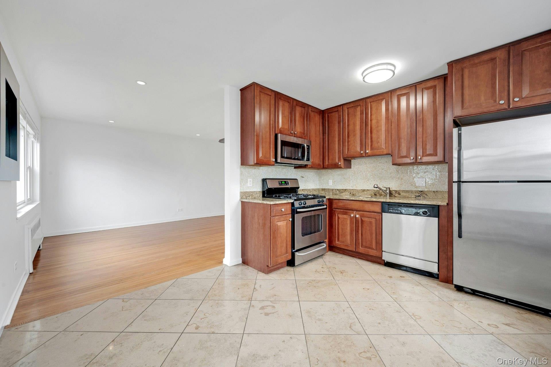 184 Purchase Street, Unit 12 Rye, NY 10580 - Photo 13 of 33 a kitchen with stainless steel appliances granite countertop a stove top oven a sink and dishwasher