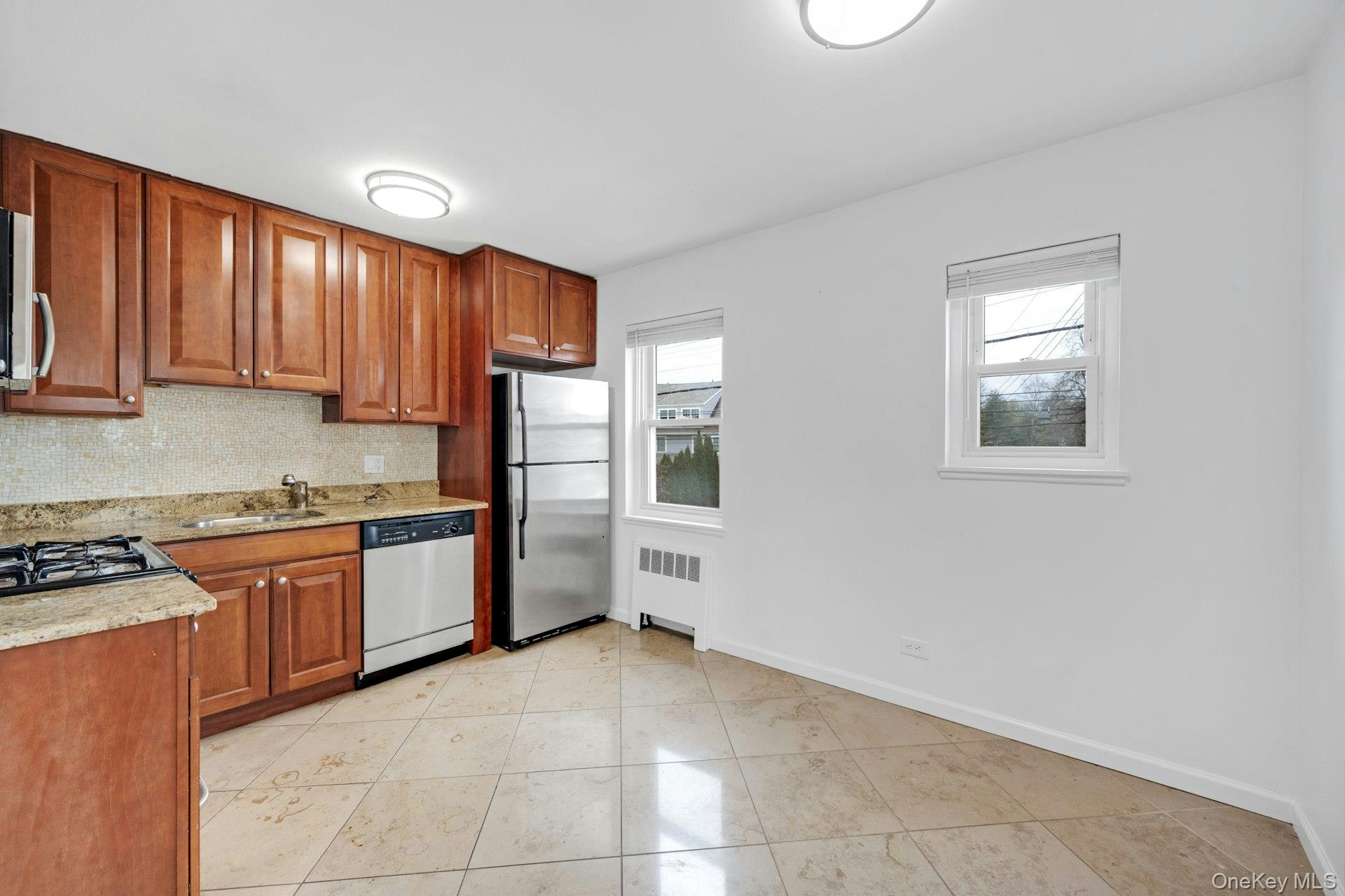 184 Purchase Street, Unit 12 Rye, NY 10580 - Photo 15 of 33 a kitchen with stainless steel appliances granite countertop wooden cabinets a stove top oven a sink and dishwasher