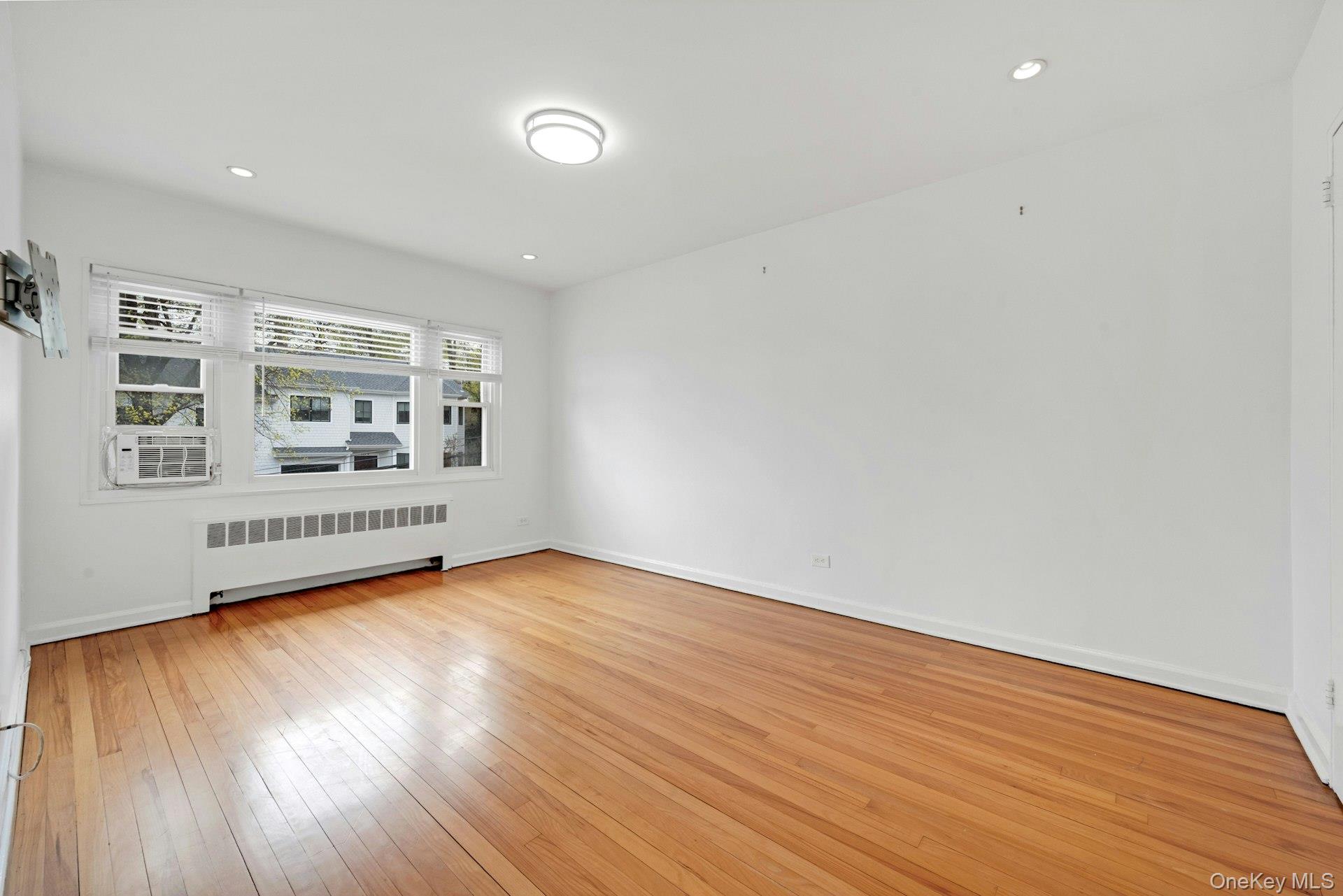 184 Purchase Street, Unit 12 Rye, NY 10580 - Photo 18 of 33 a view of an empty room with wooden floor and a window