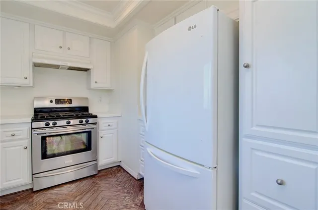 a kitchen with white cabinets and white appliances