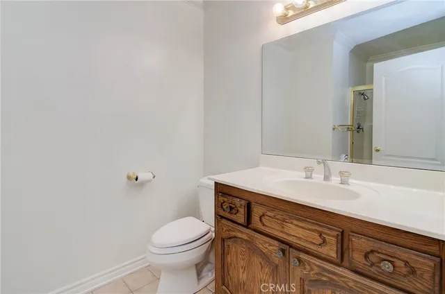 a bathroom with a granite countertop toilet sink and mirror