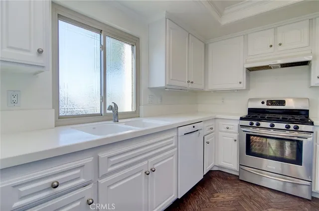 a kitchen with granite countertop white cabinets and white stainless steel appliances