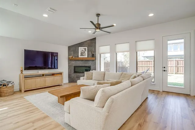 a living room with furniture a flat screen tv and a fireplace