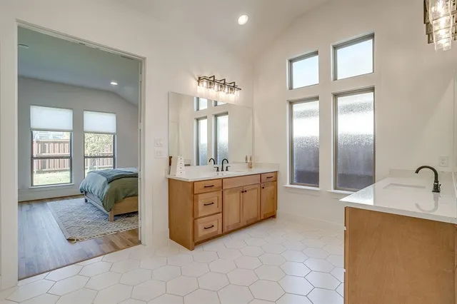 a en suite bathroom with a double vanity sink tub and mirror