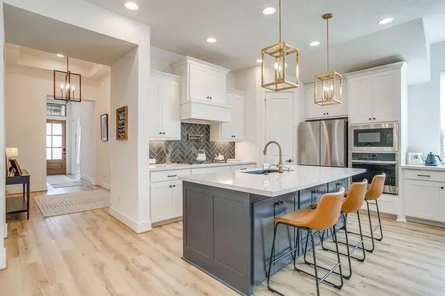 a kitchen with kitchen island granite countertop a sink a center island and cabinets