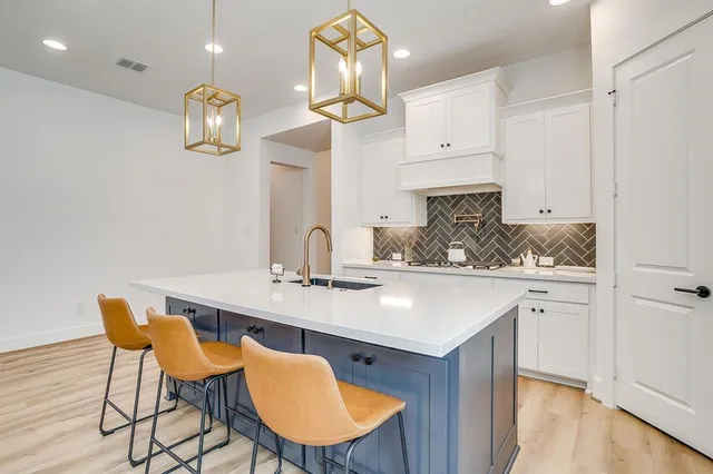 a kitchen with a sink cabinets and wooden floor