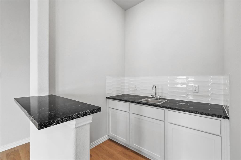 530 Red Barn Drive Van Alstyne, TX 75495 - Photo 11 of 40 Kitchen with white cabinets, light wood-style flooring, a peninsula, and dark stone countertops