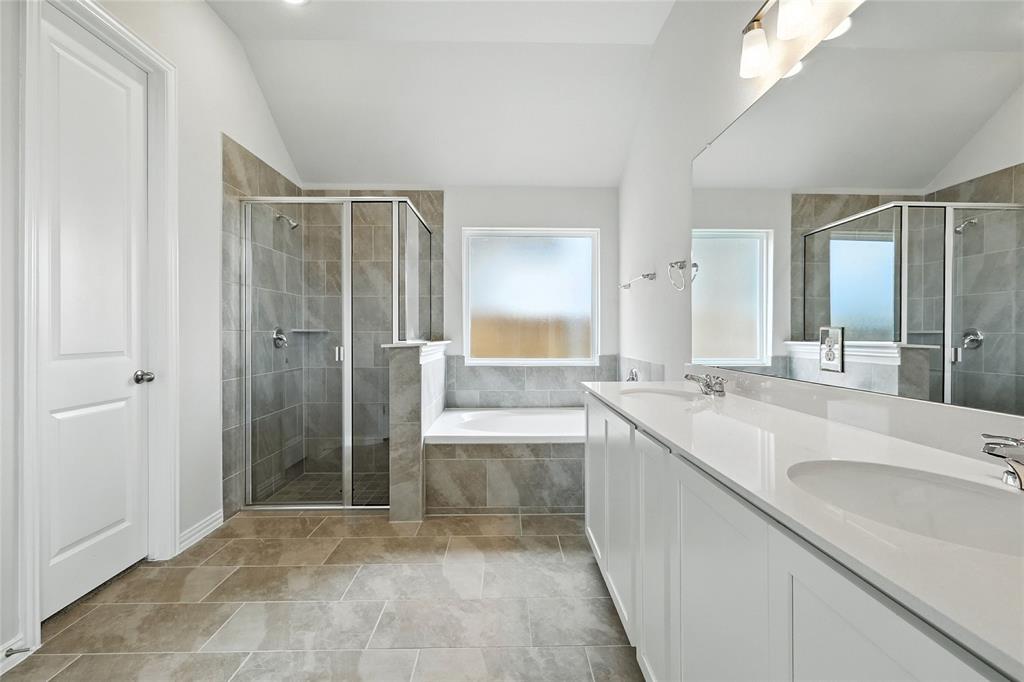 530 Red Barn Drive Van Alstyne, TX 75495 - Photo 19 of 40 Bathroom featuring lofted ceiling, double vanity, a stall shower, and a garden tub