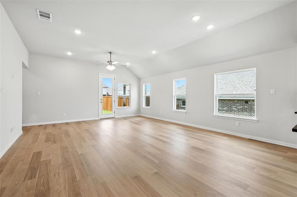530 Red Barn Drive Van Alstyne, TX 75495 - Photo 8 of 40 Unfurnished living room with a ceiling fan, light wood finished floors, lofted ceiling, and recessed lighting