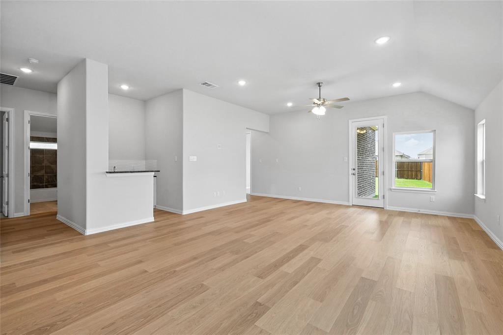 530 Red Barn Drive Van Alstyne, TX 75495 - Photo 10 of 40 Unfurnished living room with a ceiling fan, light wood-style flooring, vaulted ceiling, and recessed lighting