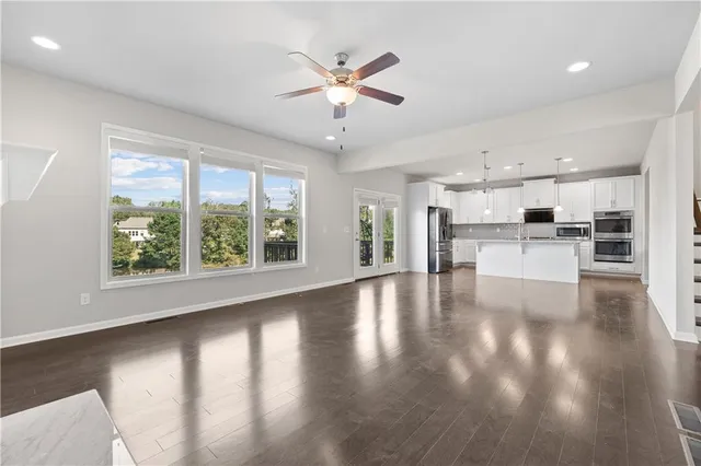 a view of a kitchen with a sink dishwasher a refrigerator with wooden floor and a kitchen view