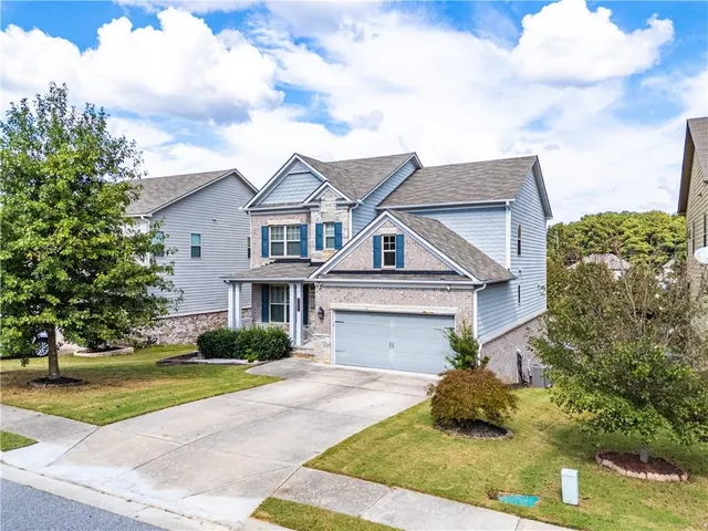 a front view of a house with a garden