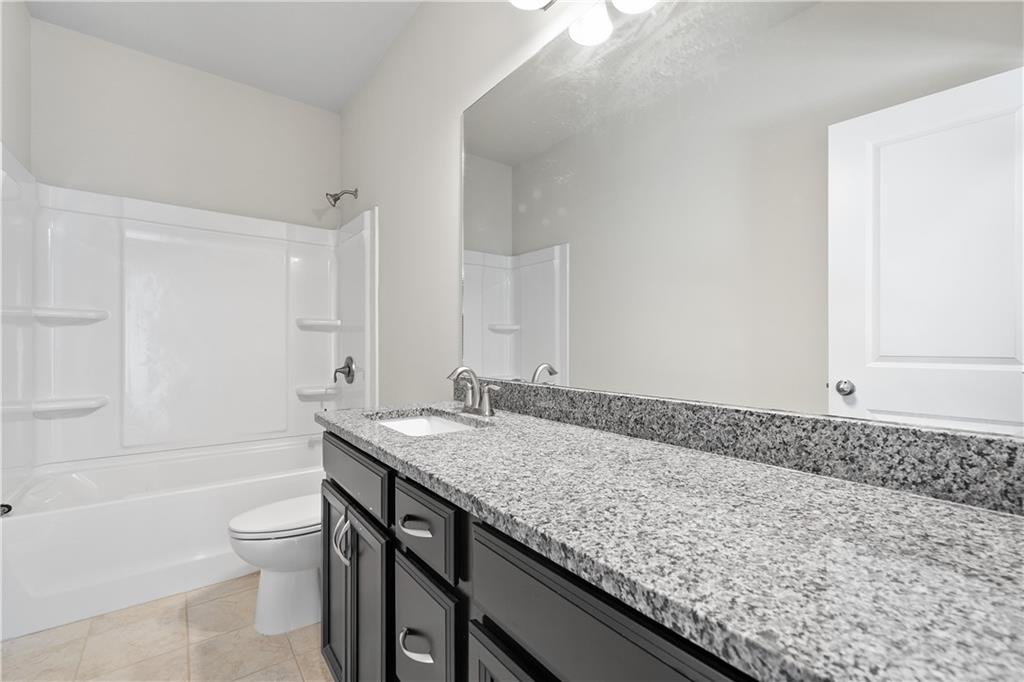 2375 Matlin Way Buford, GA 30519 - Photo 23 of 58 a bathroom with a granite countertop sink a toilet and bathtub