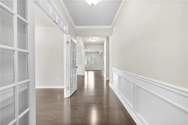 a view of an empty room with wooden floor and stairs