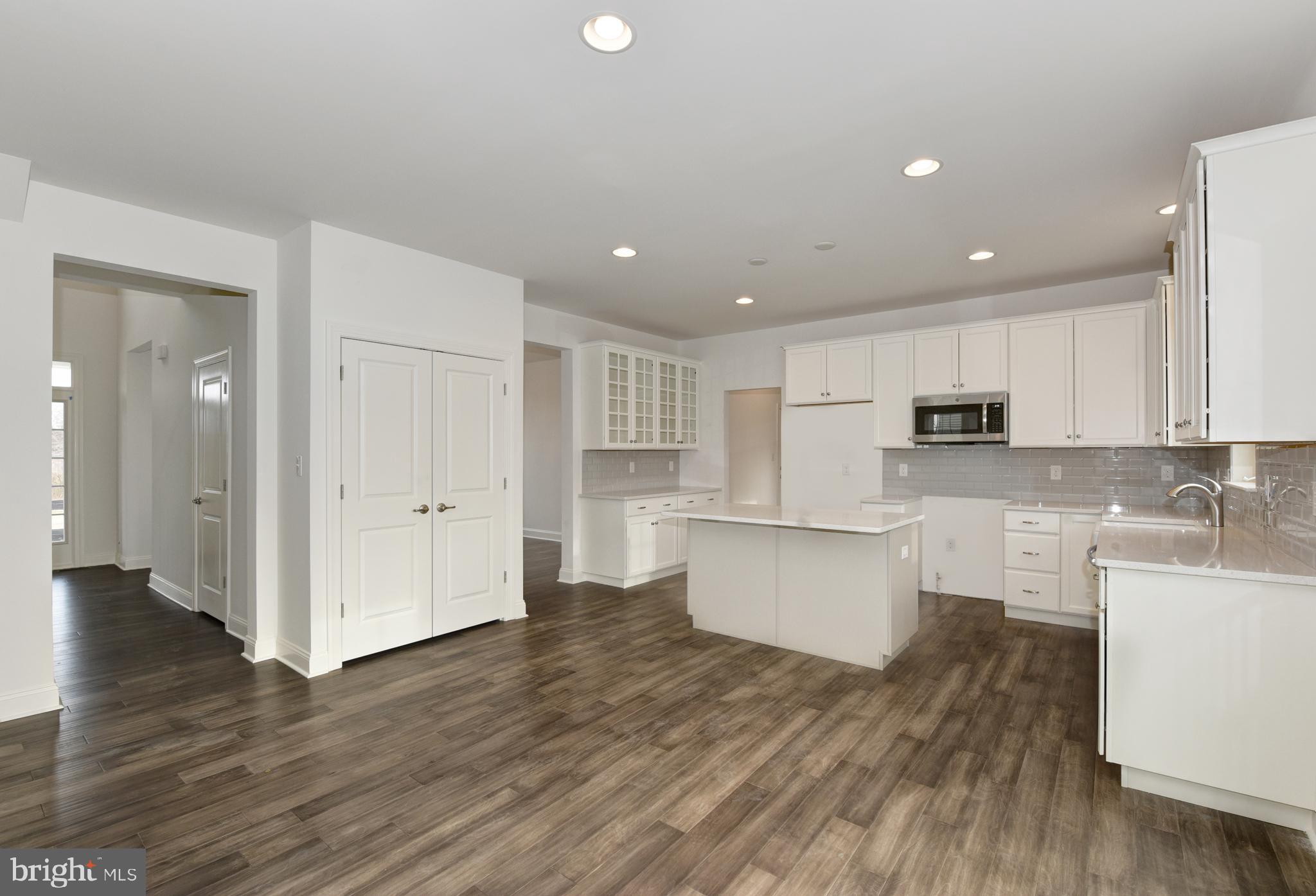 400 Rederick Lane, Unit 2 Middletown, DE 19709 - Photo 7 of 23 a large kitchen with white cabinets a sink and wooden floors