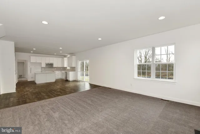 an empty room with a kitchen and windows