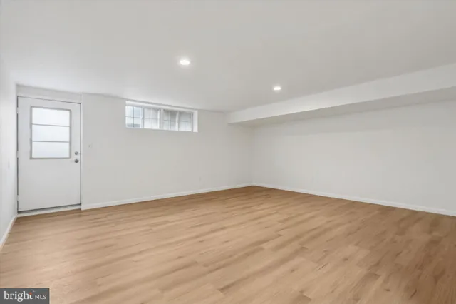a view of an empty room with wooden floor and closet