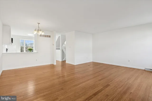 a view of empty room with wooden floor and window