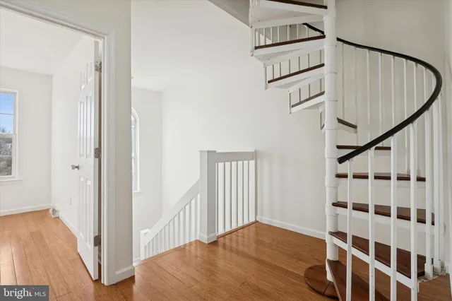 a view of a hallway with wooden floor and entryway