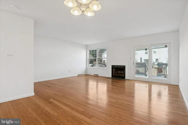 an empty room with wooden floor and fireplace