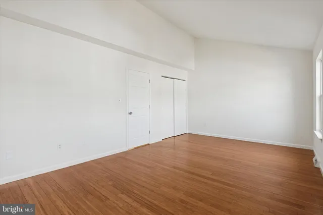 a view of empty room with wooden floor
