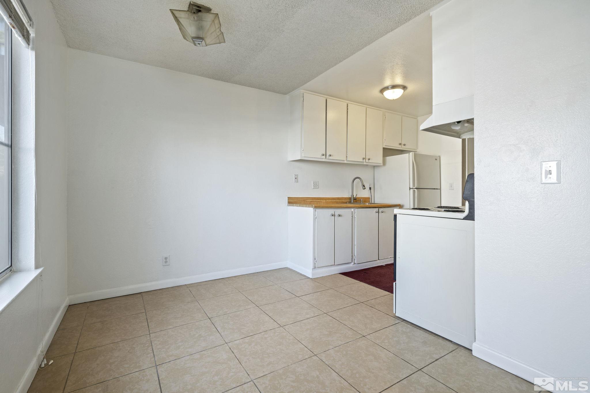 4606 Neil Road, Unit 193 Reno, NV 89502 - Photo 14 of 28 a kitchen with white cabinets and refrigerator