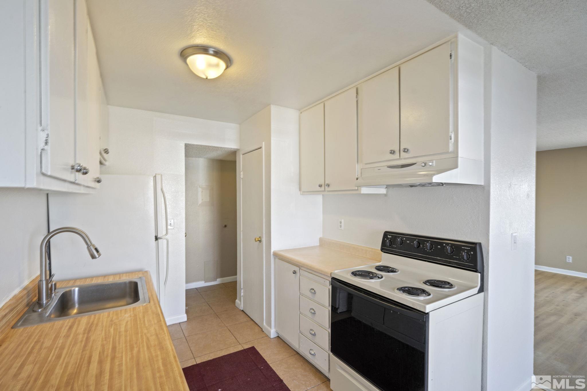 4606 Neil Road, Unit 193 Reno, NV 89502 - Photo 17 of 28 a kitchen with a stove and a white wooden cabinets