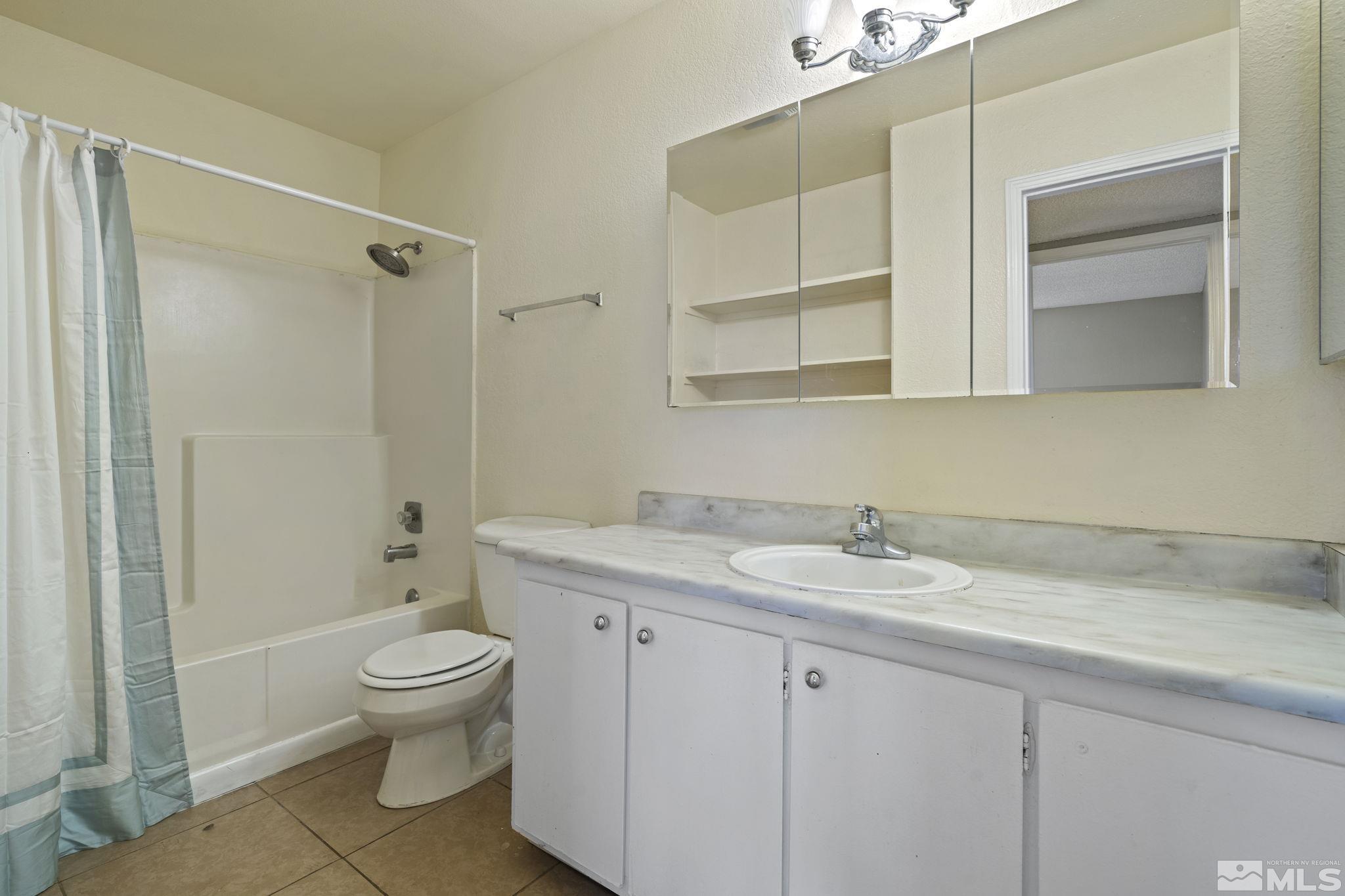 4606 Neil Road, Unit 193 Reno, NV 89502 - Photo 25 of 28 a bathroom with a granite countertop sink toilet and shower