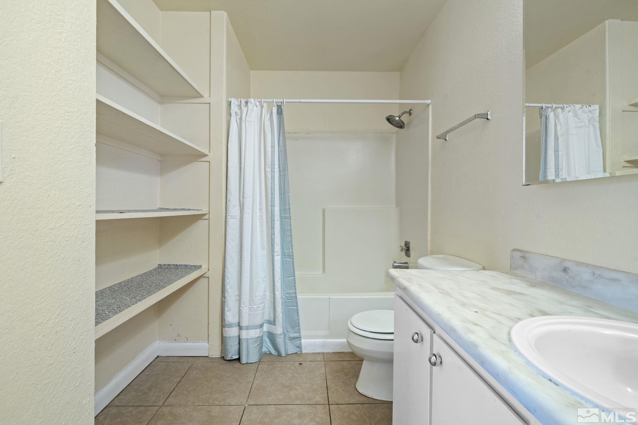 4606 Neil Road, Unit 193 Reno, NV 89502 - Photo 26 of 28 a bathroom with a granite countertop sink toilet and shower