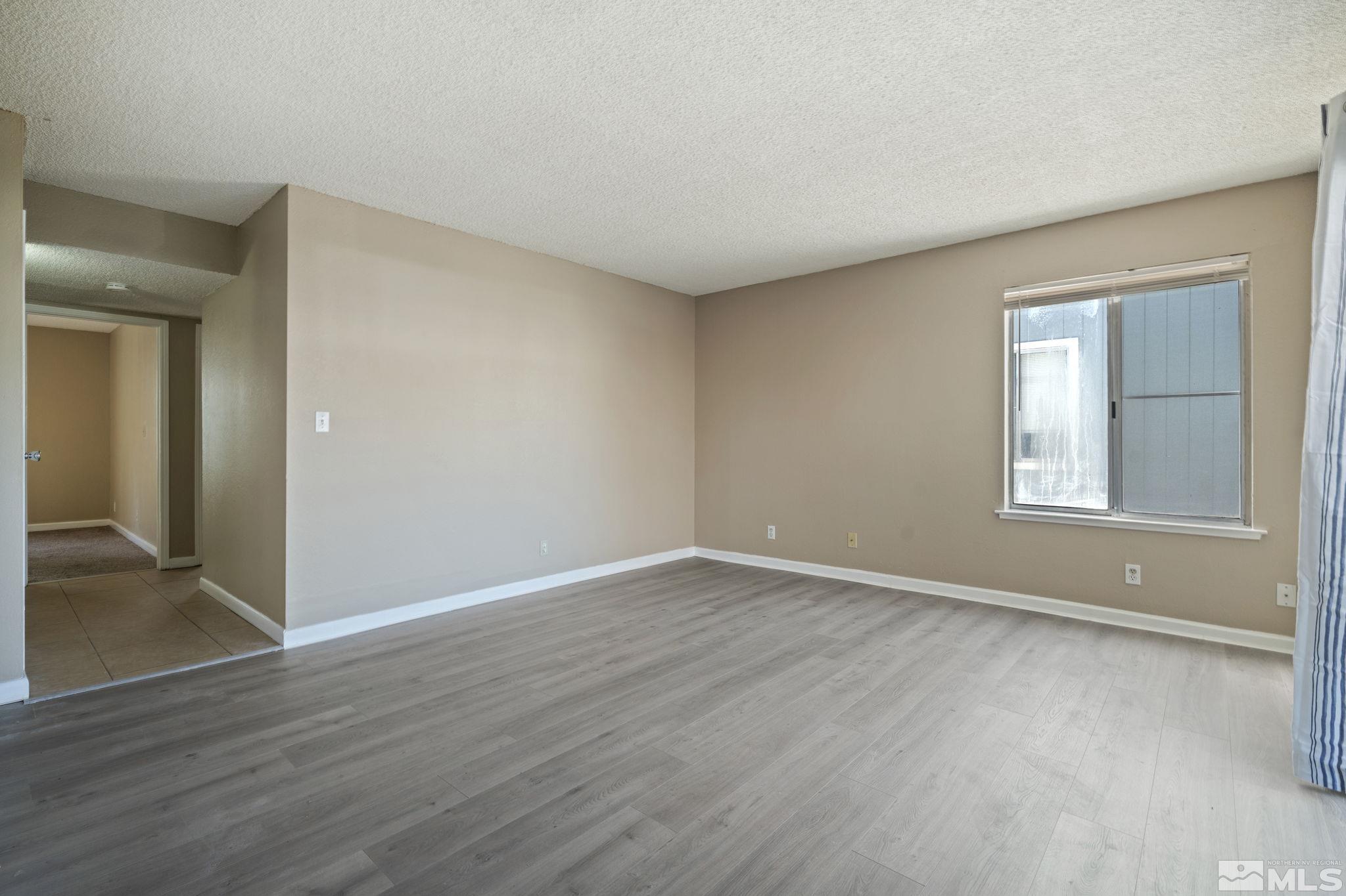 4606 Neil Road, Unit 193 Reno, NV 89502 - Photo 8 of 28 an empty room with wooden floor and windows