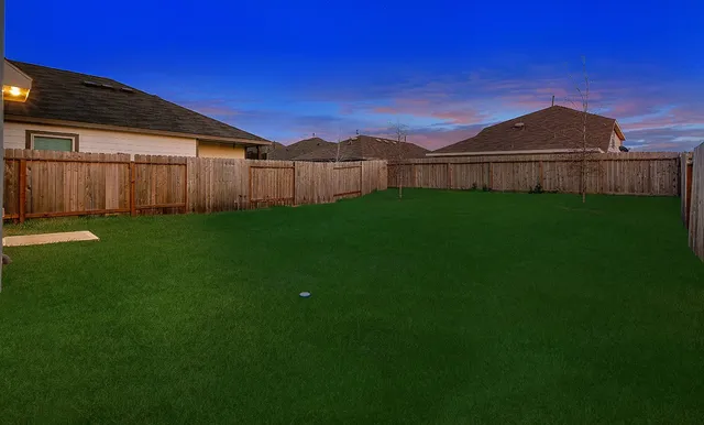 a view of a backyard with wooden fence