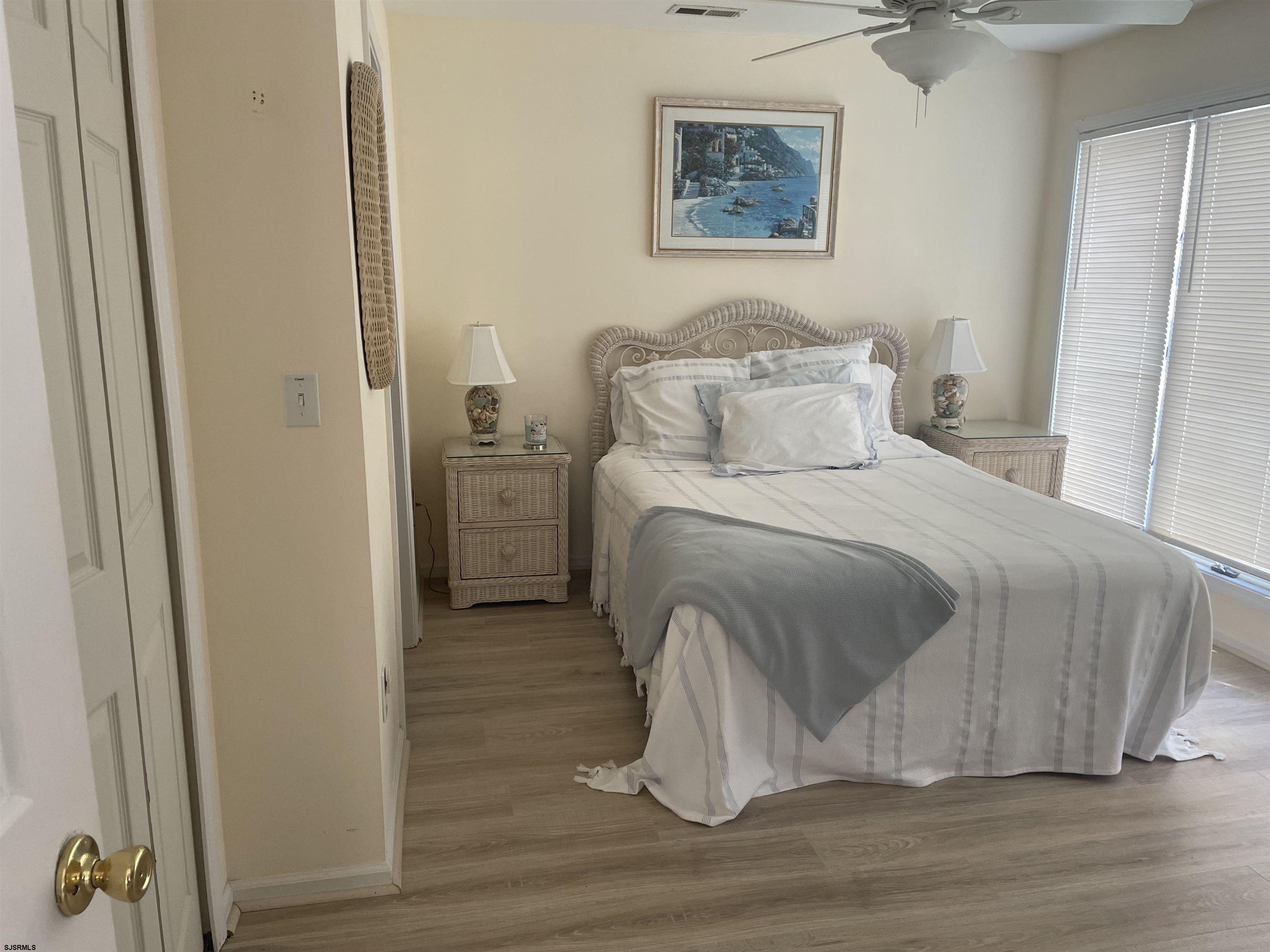 323 44th Street South, Unit 108 Brigantine, NJ 08203 - Photo 4 of 7 a large bed sitting in a bedroom next to a bathroom