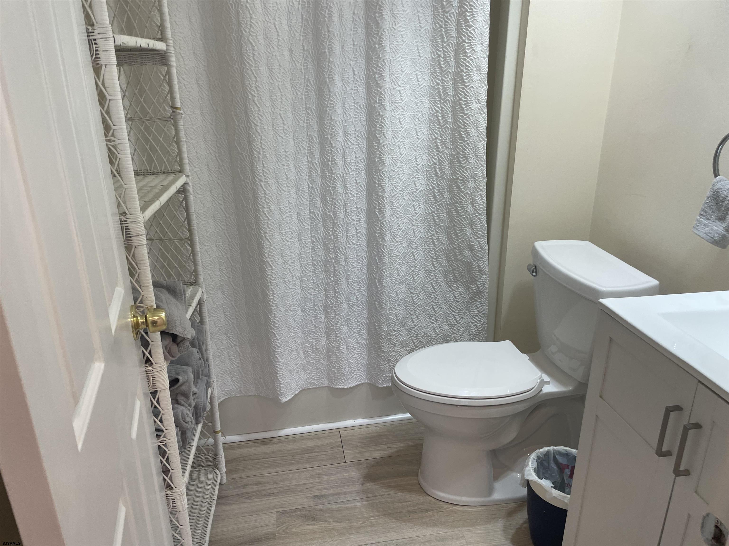 323 44th Street South, Unit 108 Brigantine, NJ 08203 - Photo 6 of 7 a white toilet sitting next to a shower curtain