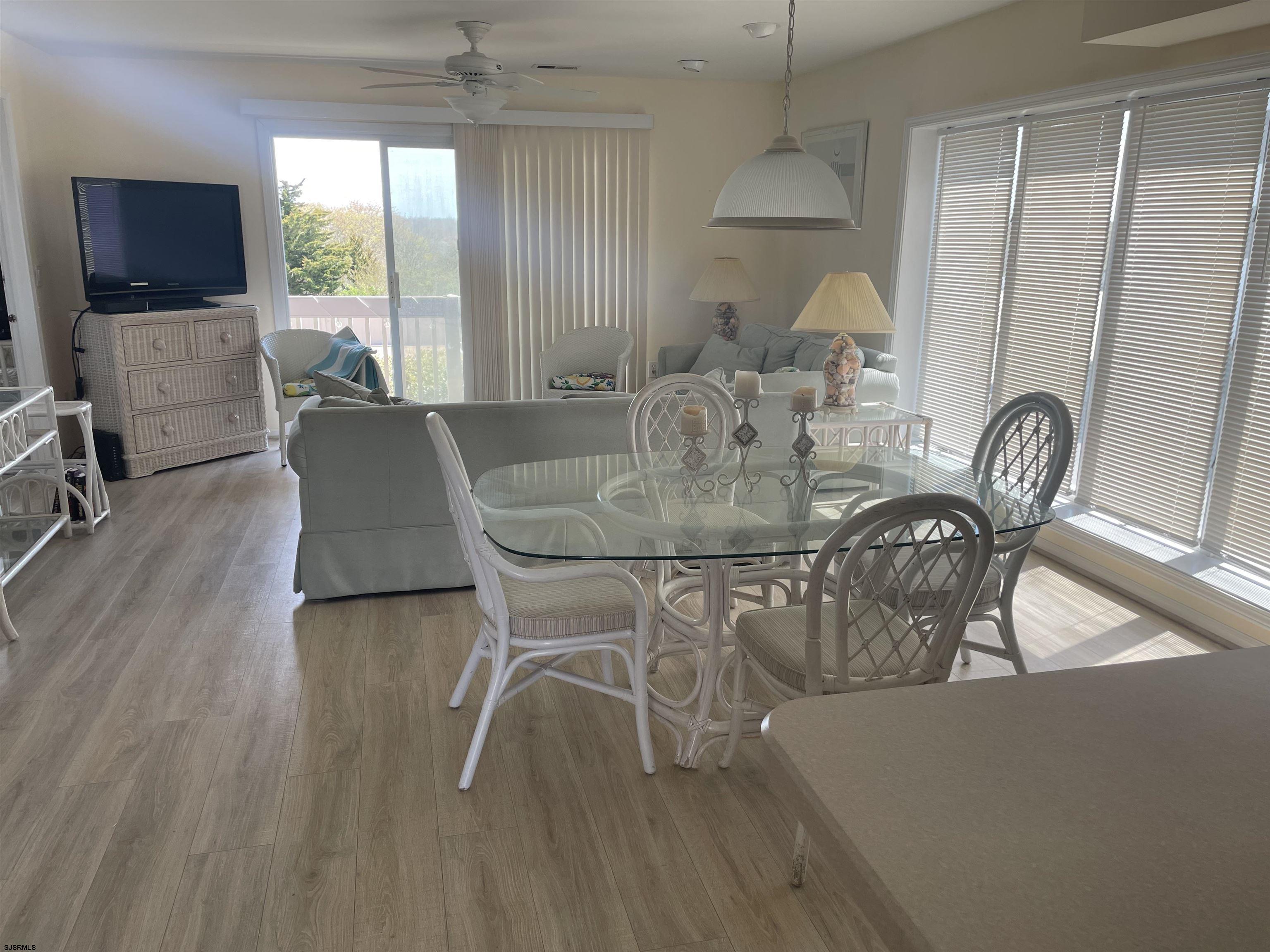 323 44th Street South, Unit 108 Brigantine, NJ 08203 - Photo 7 of 7 a dining room with furniture a chandelier and wooden floor