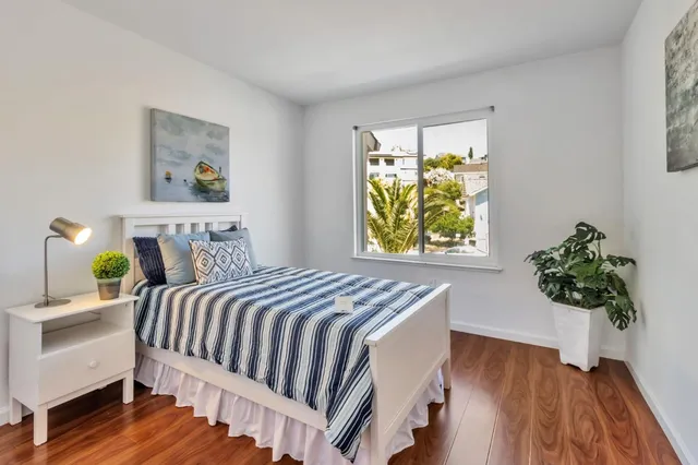 a bedroom with bed and wooden floor