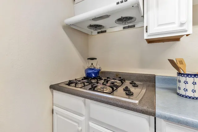 a patio with table and chairs and potted plants