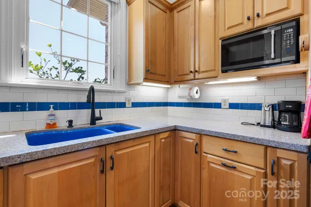 a kitchen with stainless steel appliances granite countertop a sink and a microwave