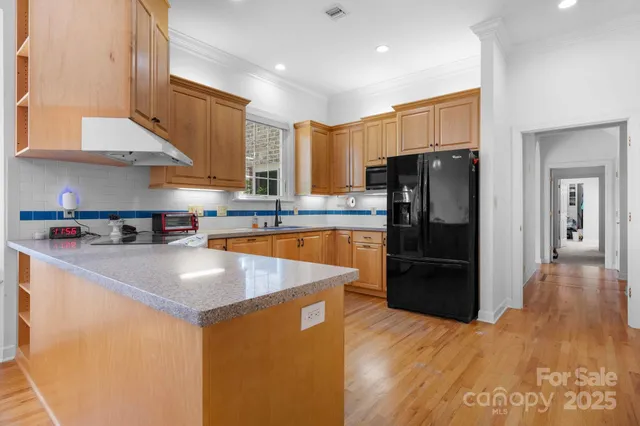 a kitchen with stainless steel appliances granite countertop a refrigerator a sink and a stove