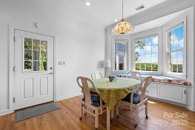 a dining room with furniture a chandelier and wooden floor