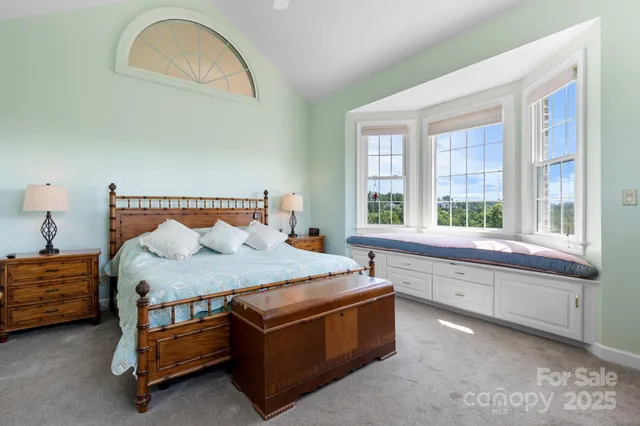 a bedroom with a bed and a large window