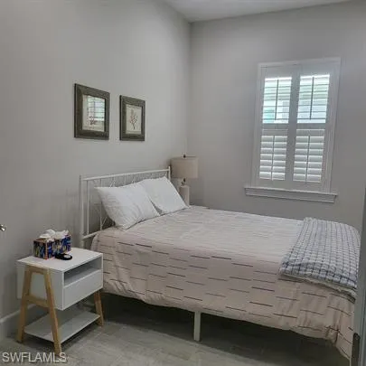 a bedroom with a bed window and table