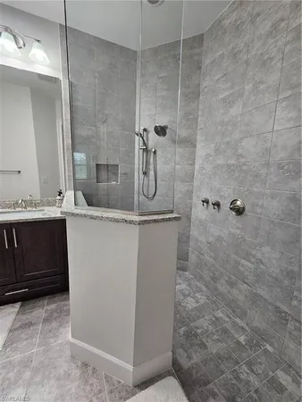 a bathroom with a granite countertop sink a toilet and shower